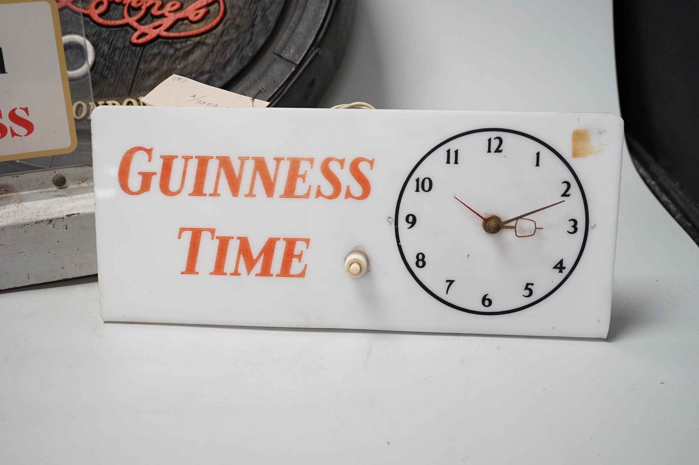 A Guinness time illuminating timepiece, Guinness display light and a Guinness advertising barrel cover
